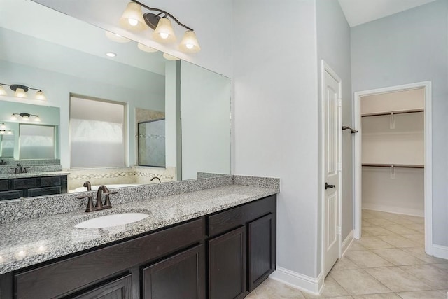 4813 Loures Ln, League City, TX 77573 - full bathroom featuring a spacious closet, tile patterned floors, vanity, baseboards, and a stall shower
