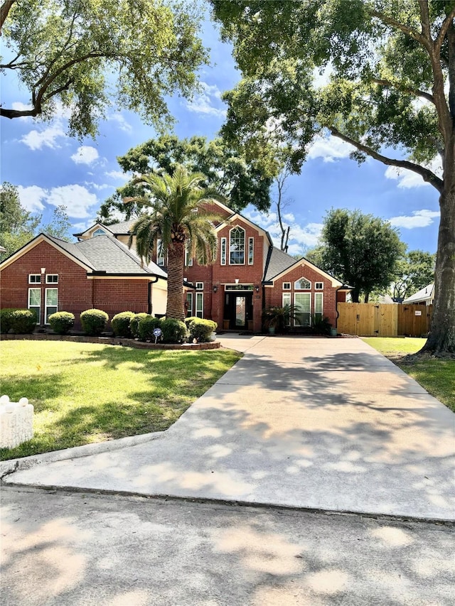 11423 Corola Trail Dr, Houston, TX 77066 - view of front facade featuring brick siding, driveway, fence, and a front lawn