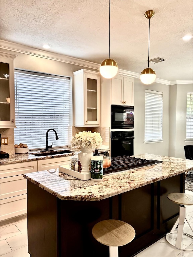 11423 Corola Trail Dr, Houston, TX 77066 - kitchen with a textured ceiling, a kitchen island, black appliances, a healthy amount of sunlight, and a sink