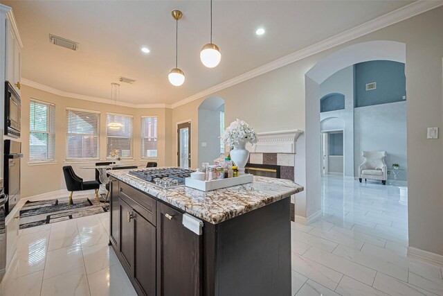 11423 Corola Trail Dr, Houston, TX 77066 - kitchen with arched walkways, ornamental molding, a center island, light stone countertops, and decorative light fixtures