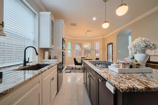 11423 Corola Trail Dr, Houston, TX 77066 - kitchen featuring light marble finish floors, stainless steel gas stovetop, white cabinets, arched walkways, and ornamental molding