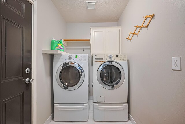 11423 Corola Trail Dr, Houston, TX 77066 - washroom with separate washer and dryer, cabinet space, and a textured ceiling