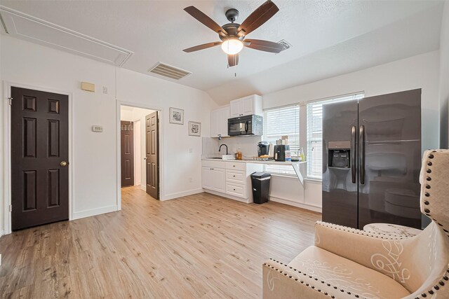 11423 Corola Trail Dr, Houston, TX 77066 - kitchen featuring stainless steel refrigerator with ice dispenser, black microwave, light countertops, light wood-style flooring, and white cabinetry