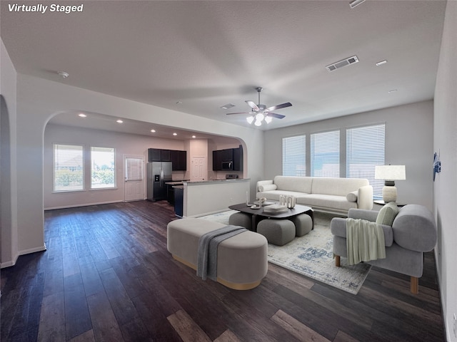 24410 Bludana Ln, Richmond, TX 77406 - living area featuring arched walkways, dark wood-type flooring, visible vents, and ceiling fan