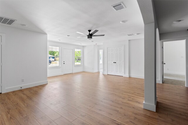 unfurnished living room with visible vents, ceiling fan, and wood finished floors