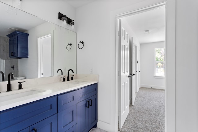 bathroom featuring a sink, baseboards, double vanity, and toilet
