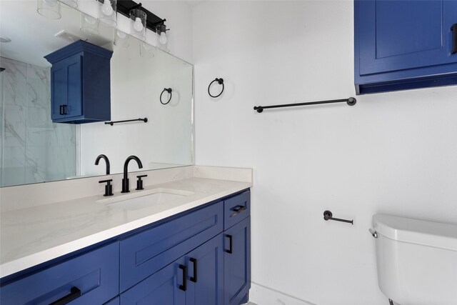 bathroom with toilet, vanity, visible vents, and a shower
