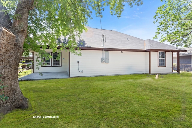 back of property featuring fence and a lawn