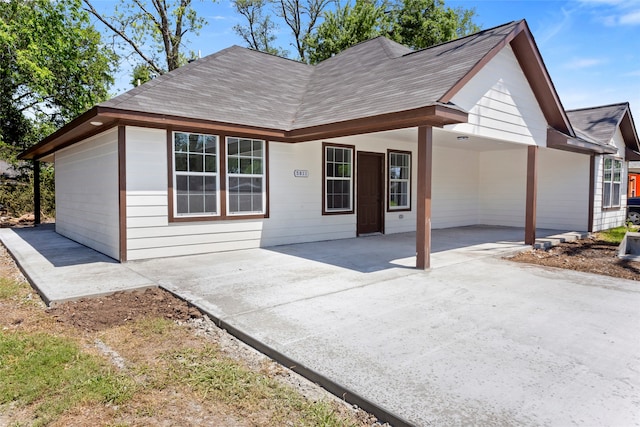 view of front of house with a carport and a shingled roof