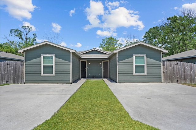 ranch-style house with a front yard, driveway, and fence