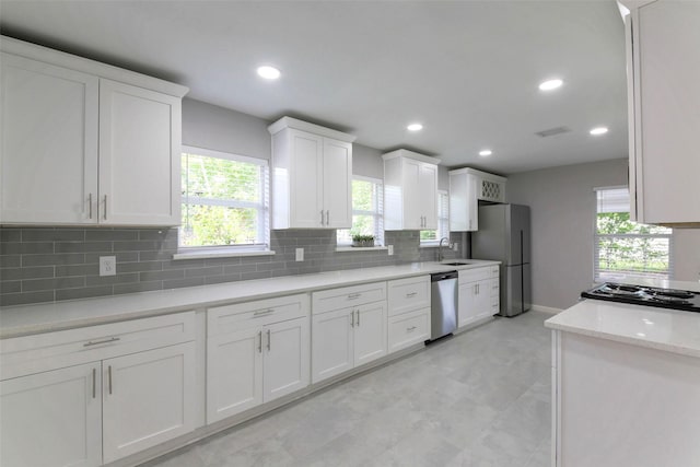 3605 Barberry Dr, Houston, TX 77051 - kitchen featuring white cabinets, a sink, appliances with stainless steel finishes, recessed lighting, and decorative backsplash