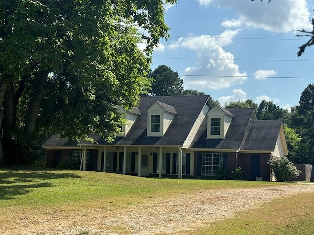cape cod home featuring a front yard and dirt driveway