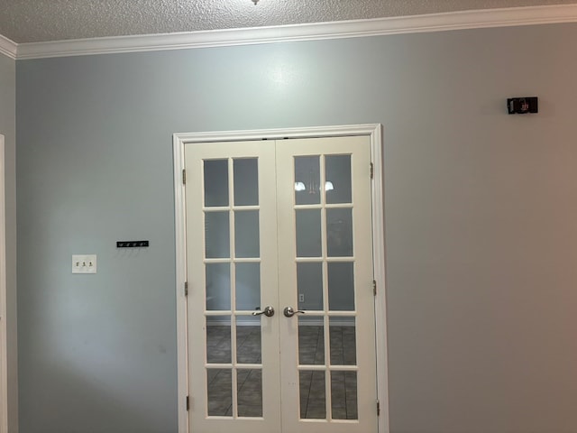 entryway with french doors, a textured ceiling, and ornamental molding