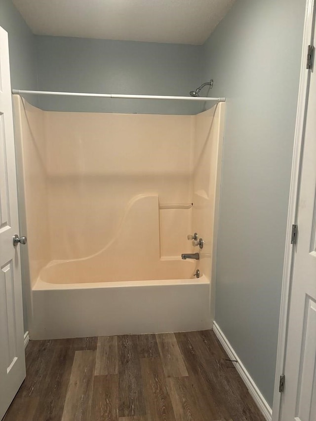 bathroom featuring wood finished floors and tub / shower combination
