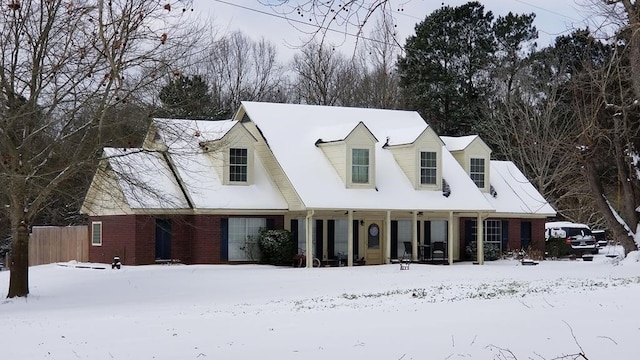 view of front of house featuring brick siding and fence