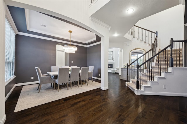 dining area with arched walkways, baseboards, stairway, and hardwood / wood-style floors