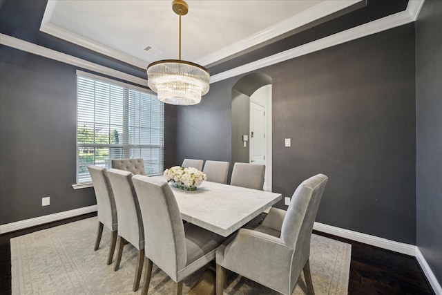 dining room featuring visible vents, arched walkways, wood finished floors, a notable chandelier, and ornamental molding