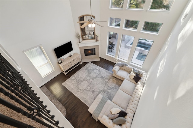 living room featuring a high ceiling, plenty of natural light, and a tile fireplace