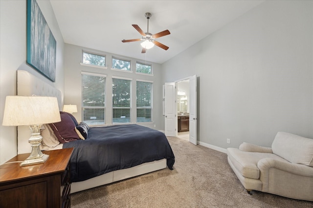 bedroom with a ceiling fan, baseboards, a high ceiling, carpet flooring, and ensuite bath