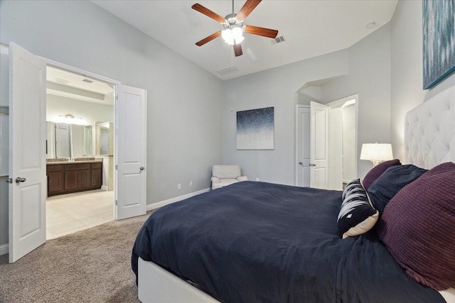 bedroom featuring light carpet, baseboards, ensuite bathroom, lofted ceiling, and visible vents