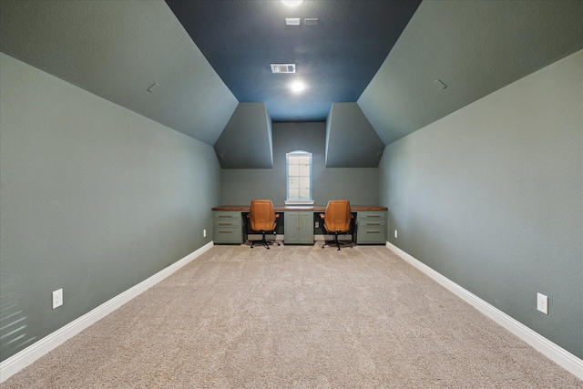 office area featuring baseboards, visible vents, light carpet, and lofted ceiling