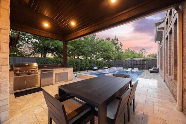 view of patio featuring a fenced backyard, outdoor dining area, a grill, and area for grilling