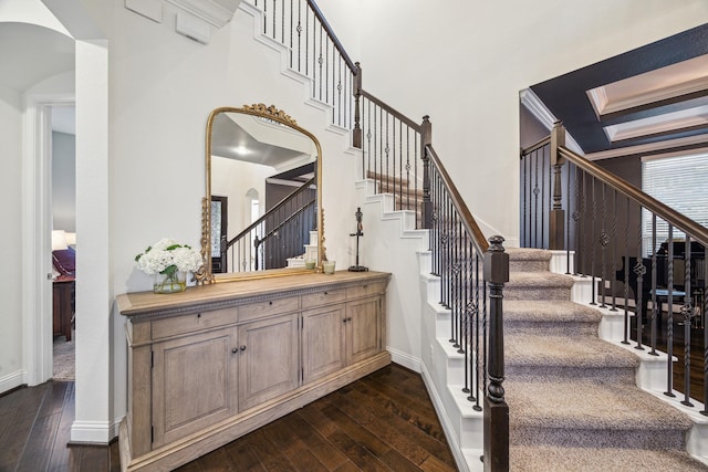 stairs with wood-type flooring, arched walkways, baseboards, and a skylight