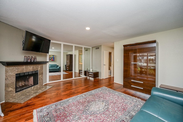 living room with recessed lighting, a fireplace, visible vents, and wood finished floors
