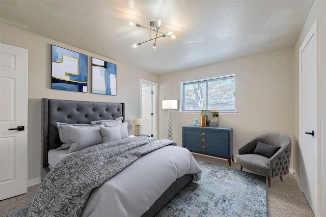 carpeted bedroom featuring baseboards and a notable chandelier