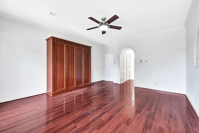 interior space featuring baseboards, dark wood-style floors, crown molding, visible vents, and arched walkways