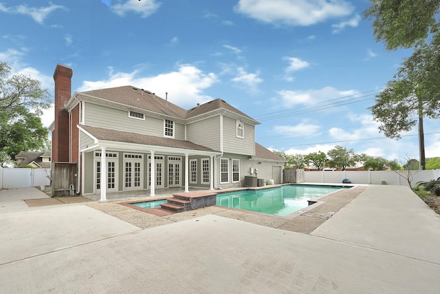 view of pool featuring a patio area, french doors, central AC, and a fenced backyard