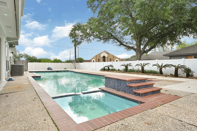 view of swimming pool with a patio area, a fenced backyard, a pool with connected hot tub, and central air condition unit