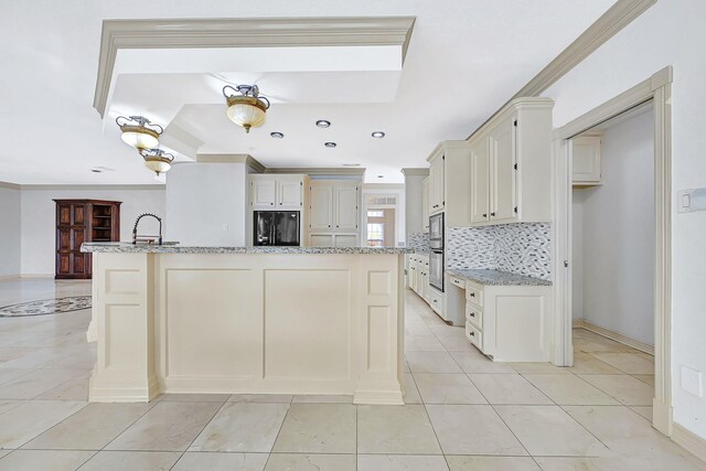 kitchen featuring crown molding, backsplash, oven, and black fridge