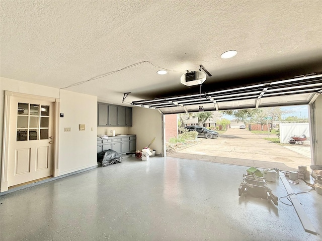 garage with recessed lighting and a garage door opener