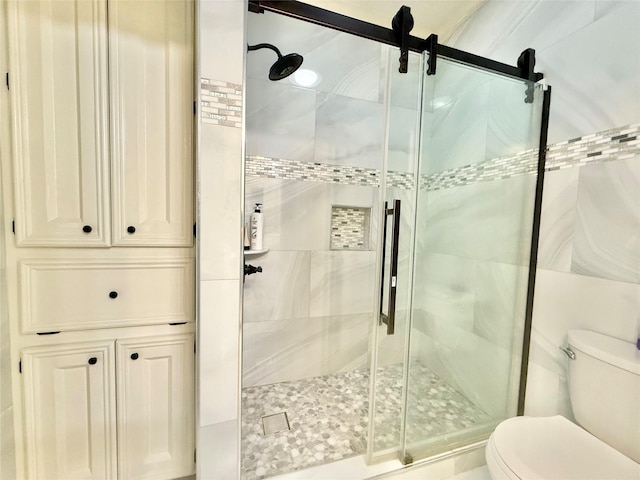 full bath featuring a shower stall and toilet