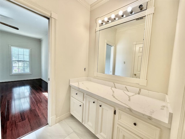 bathroom featuring ceiling fan, vanity, baseboards, and ornamental molding