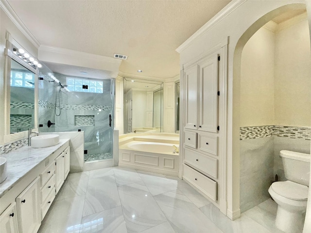 bathroom featuring visible vents, ornamental molding, a sink, a bath, and a stall shower