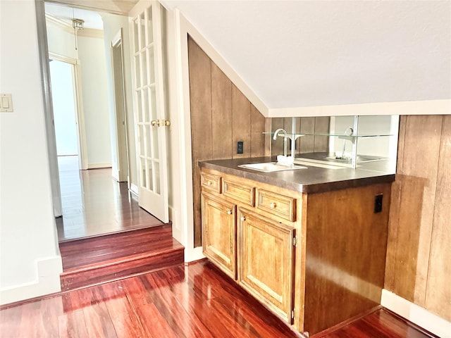 bar with a sink and dark wood-type flooring