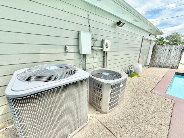 exterior details featuring a pool, electric meter, central AC, and fence