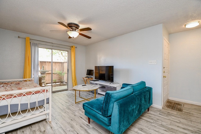 10555 Turtlewood Ct Unit 2606, Houston, TX 77072 - living room featuring a ceiling fan, wood finished floors, and a textured ceiling