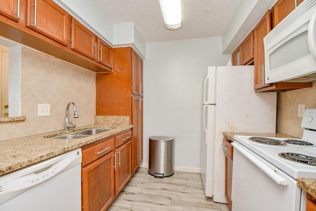 10555 Turtlewood Ct Unit 2606, Houston, TX 77072 - kitchen with a sink, white appliances, brown cabinets, backsplash, and light wood-style flooring