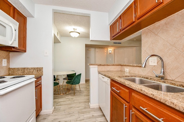10555 Turtlewood Ct Unit 2606, Houston, TX 77072 - kitchen featuring a sink, decorative backsplash, light wood-type flooring, and white appliances