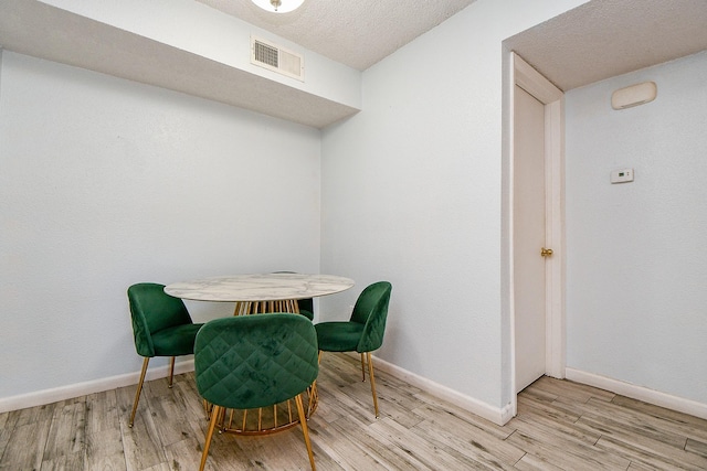 10555 Turtlewood Ct Unit 2606, Houston, TX 77072 - dining room featuring light wood-style floors, visible vents, baseboards, and a textured ceiling
