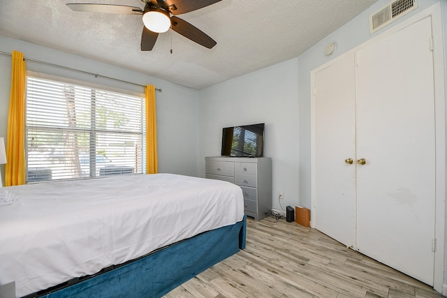 10555 Turtlewood Ct Unit 2606, Houston, TX 77072 - bedroom with light wood-type flooring, visible vents, a textured ceiling, and ceiling fan