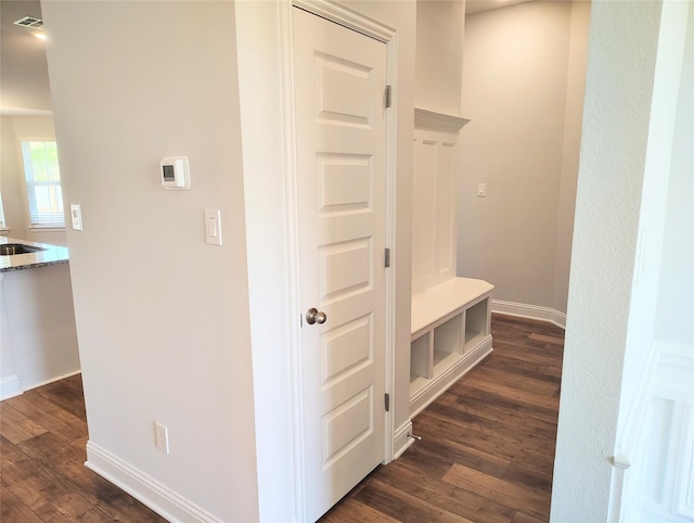mudroom with visible vents, baseboards, and dark wood finished floors