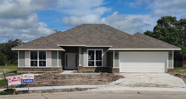view of front facade with brick siding, roof with shingles, driveway, and a garage