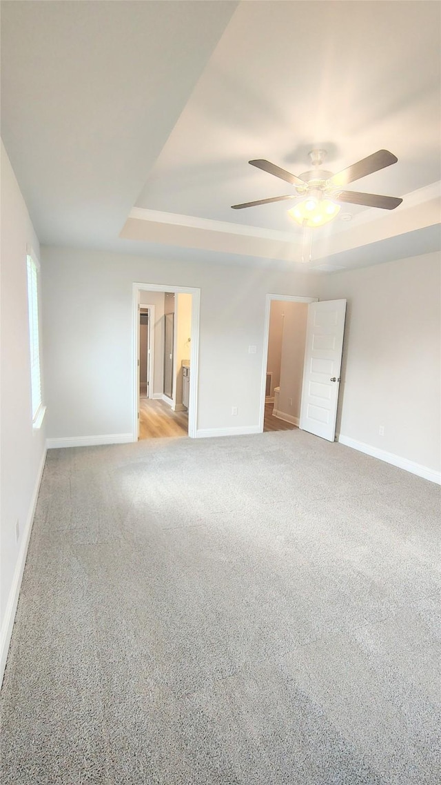9 Gemstone Ct, Angleton, TX 77515 - unfurnished room featuring a raised ceiling, baseboards, a ceiling fan, and light carpet