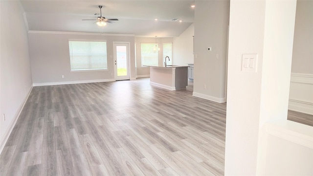 9 Gemstone Ct, Angleton, TX 77515 - unfurnished living room featuring ceiling fan, light wood finished floors, a sink, crown molding, and baseboards