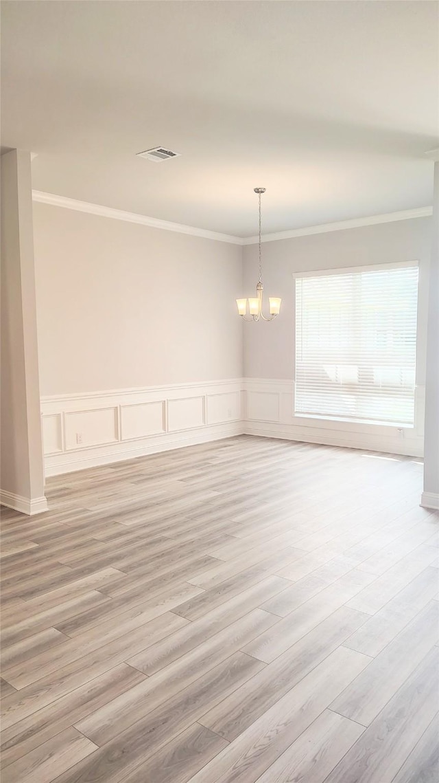 9 Gemstone Ct, Angleton, TX 77515 - spare room with crown molding, a chandelier, light wood finished floors, and wainscoting