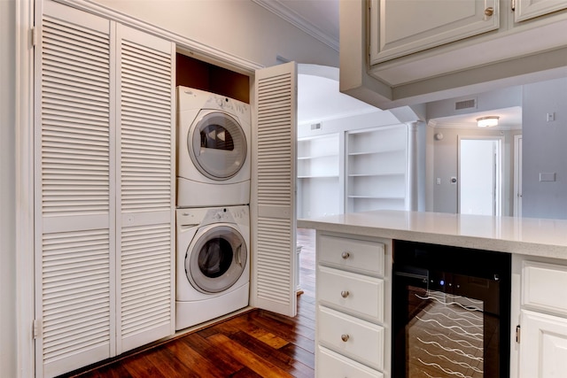 2111 Welch St Unit A107, Houston, TX 77019 - laundry room with stacked washer and clothes dryer, wine cooler, crown molding, and dark wood-style flooring